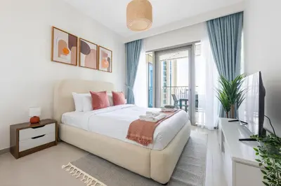 a white bedroom with a bed and a balcony at Amazing Patio Experience - Best Burj Khalifa View in Dubai