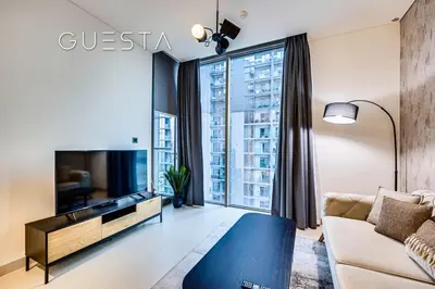 a living room with a couch and a tv at Sobha Creek Vistas, Sobha Hartland, MBR City, Dubai in Dubai