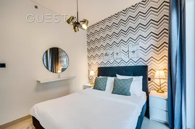 a bedroom with a white bed and a chevron wall at Sobha Creek Vistas, Sobha Hartland, MBR City, Dubai in Dubai