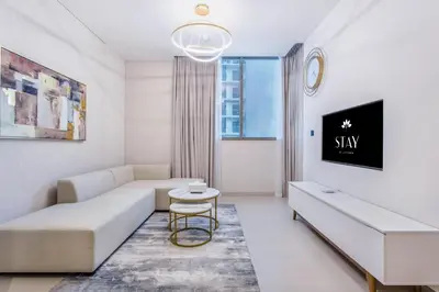 a white living room with a couch and a table at STAY BY LATINEM Luxury 1BR Holiday Home CV A1507 near Burj Khalifa in Dubai