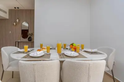 a dining room table with chairs and orange juice at Amazing Seaview Prime Location Upgraded in Dubai