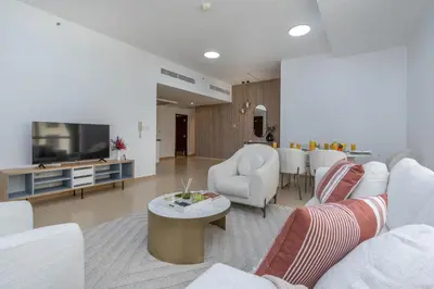 a living room with a couch and a tv at Amazing Seaview Prime Location Upgraded in Dubai