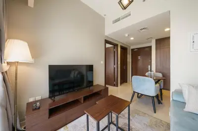 a living room with a television and a chair at 1BR near Dubai Mall 10 Min walking distance in Dubai