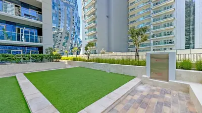 a lawn in the middle of a building with tall buildings at 1BR near Dubai Mall 10 Min walking distance in Dubai