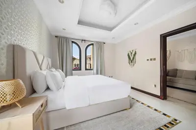 a white bedroom with a large bed and a mirror at Beachfront Dubai Villa for 10 Guests with Full Kitchen & View in Dubai