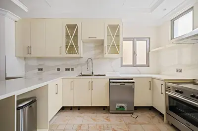 a kitchen with white cabinets and a sink at Beachfront Dubai Villa for 10 Guests with Full Kitchen & View in Dubai