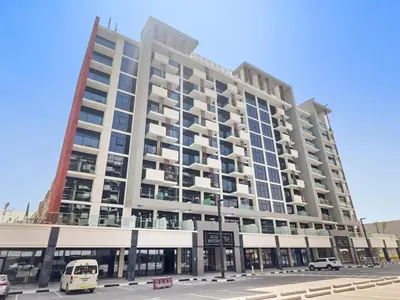 a large building on a city street with a bus at StoneTree - Azizi Riviera 36 Studio - Brand new in Dubai