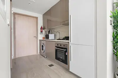 a kitchen with a stove and a refrigerator at StoneTree - Azizi Riviera 36 Studio - Brand new in Dubai