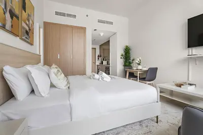 a white bedroom with a large white bed with pillows at StoneTree - Azizi Riviera 36 Studio - Brand new in Dubai