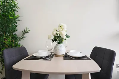 a white table with a vase with white flowers on it at StoneTree - Azizi Riviera 36 Studio - Brand new in Dubai