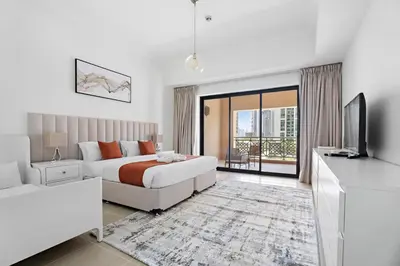 a bedroom with a bed and a tv and a couch at Stonetree - Golden Mile 4 - Beach Access in Dubai