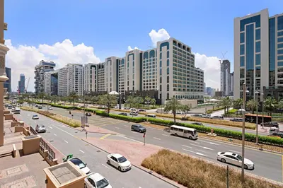 a city with cars driving on a highway with tall buildings at Stonetree - Golden Mile 4 - Beach Access in Dubai