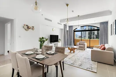 a dining room and living room with a table and chairs at Stonetree - Golden Mile 4 - Beach Access in Dubai