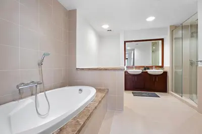 a bathroom with a bath tub and two sinks at Stonetree - Golden Mile 4 - Beach Access in Dubai