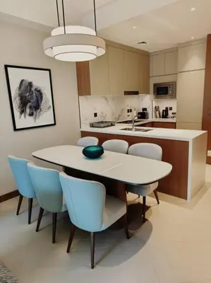 a kitchen with a white table and blue chairs at Luxury of 1 minute walk to Burj Khalifa & D/Opera in Dubai
