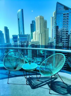 two chairs and tables on a balcony with a city skyline at Waterfront Marina Best View Amazing Location 2 Bed in Dubai