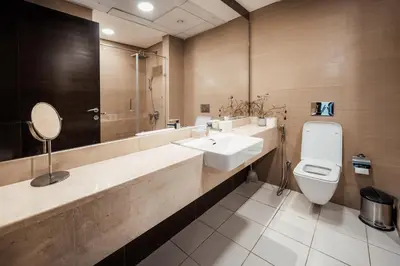 a bathroom with a sink and a toilet and a mirror at izzzi - One Bedroom Apartment, Sparkle Tower in Dubai