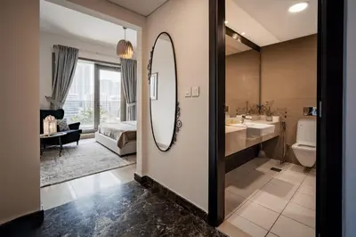 a bathroom with a mirror and a sink and a bed at izzzi - One Bedroom Apartment, Sparkle Tower in Dubai