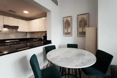 a kitchen and dining room with a table and chairs at izzzi - One Bedroom Apartment, Sparkle Tower in Dubai