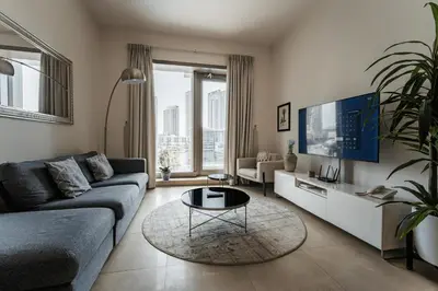 a living room with a couch and a tv at izzzi - One Bedroom Apartment, Sparkle Tower in Dubai