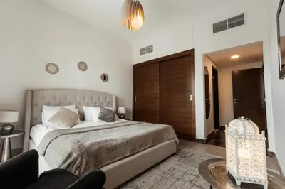 a bedroom with a large bed and a couch at izzzi - One Bedroom Apartment, Sparkle Tower in Dubai