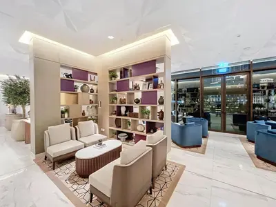 a salon with chairs and tables in a building at Palace Residences - Modern One Bedroom in Dubai