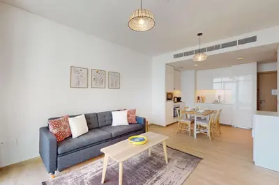 a living room with a couch and a table at Palace Residences - Modern One Bedroom in Dubai