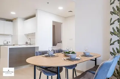 a kitchen and dining room with a wooden table and chairs at Al Andalus D I Jumeirah Golf Estates in Dubai