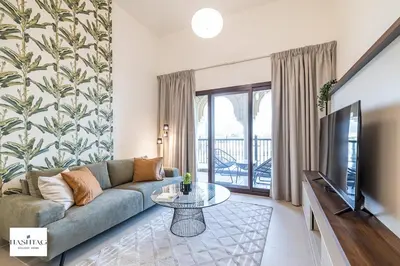 a living room with a couch and a tv at Al Andalus D I Jumeirah Golf Estates in Dubai