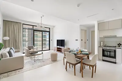 a white living room with a table and chairs at Silkhaus Chic 1BDR in Exclusive Neighbourhood in Dubai