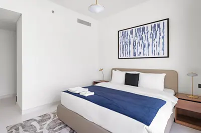 a bedroom with a large bed with a blue blanket at Silkhaus Skyline View | Exclusive Neighbourhood in Dubai