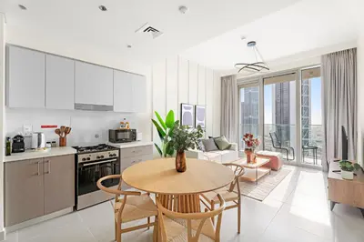 a kitchen and living room with a table and chairs at Silkhaus Chic 1 BDR In a New Tower In Downtown in Dubai