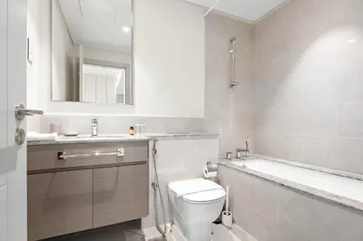 a bathroom with a toilet and a sink and a bath tub at Silkhaus Chic 1 BDR In a New Tower In Downtown in Dubai