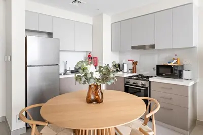 a kitchen with a wooden table with a vase of flowers at Silkhaus Chic 1 BDR In a New Tower In Downtown in Dubai
