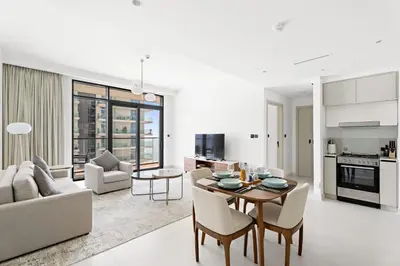a kitchen and living room with a table and chairs at Silkhaus Partial Marina View 1BDR in Marina Vista in Dubai