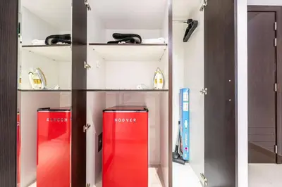 two red containers in a shelf in a room at Luxury Studio - Golf Views - Sports City Dubai in Dubai
