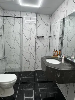 a black and white bathroom with a toilet and a sink at Stay in brand new Luxury Sport City apartment 15 in Dubai