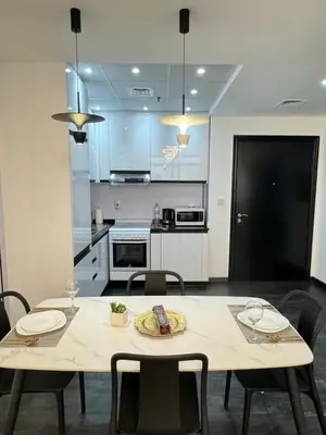 a kitchen with a table and chairs in a room at Stay in brand new Luxury Sport City apartment 15 in Dubai