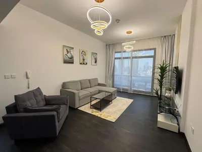 a living room with a couch and a table at Stay in brand new Luxury Sport City apartment 15 in Dubai