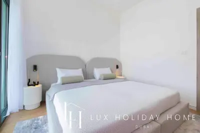 a bed in a bedroom with a luxury holiday home at LUX The Dubai Hills Executive Suite in Dubai