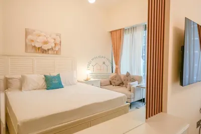 a bedroom with a bed and a couch and a mirror at Azizi Riviera 18 in Dubai