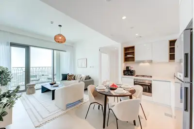 a kitchen and living room with a table and chairs at Silkhaus High Floor 1 BDR In The Heart of Downtown in Dubai
