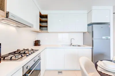 a white kitchen with a sink and a stove at Silkhaus High Floor 1 BDR In The Heart of Downtown in Dubai