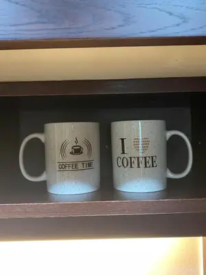 two coffee mugs sitting on a shelf at The residences 1 - Luxury 1BR apt in Downtown Dubai - 2 mins walk to Burj Khalifa & Dubai Mall in Dubai