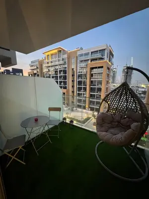 a balcony with two chairs and a table and some buildings at Chic apartment, Maydan Riviera Dubaï in Dubai