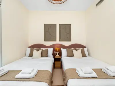 two beds in a room with white walls at Sky High 2-Bedroom Apartment Stunning Opera & Downtown Views Opp Dubai Mall in Dubai