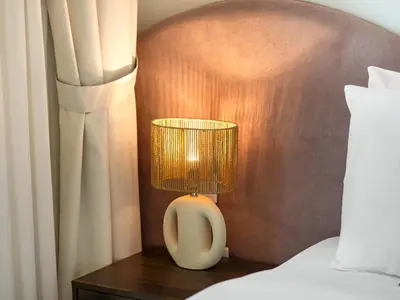 a lamp sitting on a table next to a bed at Sky High 2-Bedroom Apartment Stunning Opera & Downtown Views Opp Dubai Mall in Dubai