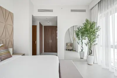 a bedroom with a white bed and two potted plants at Vida Voyage - Vida Residences - Creek Harbour in Dubai