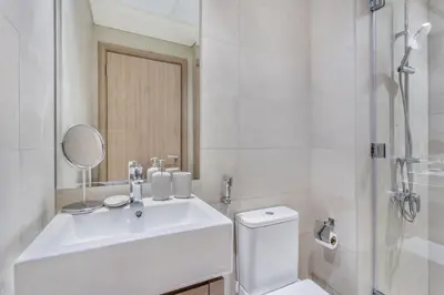 a white bathroom with a sink and a shower at Lux-Furnished Stu Couple-Friendly Near Downtown in Dubai