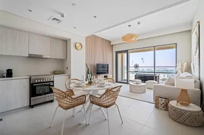 a kitchen and living room with a table and chairs at Harbour Oasis - Vida Residences - Creek Harbour in Dubai